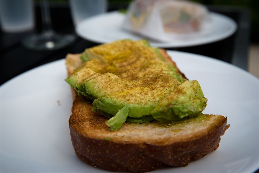 A generous brunch plate with eggs, greens, and grilled sourdough in natural cafe light