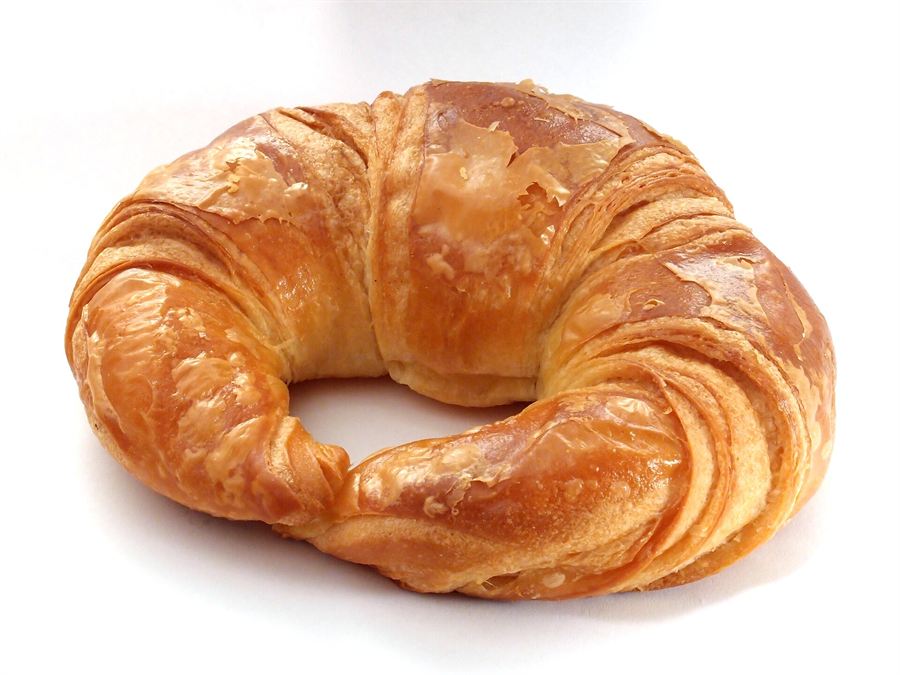 Golden croissants and cinnamon scrolls arranged on a marble cafe counter
