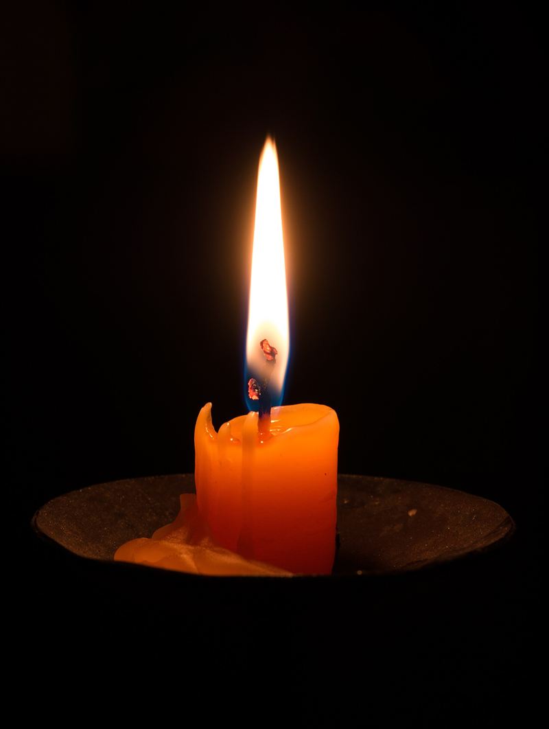 Hand-poured soy candle in an amber glass jar with a cotton wick.